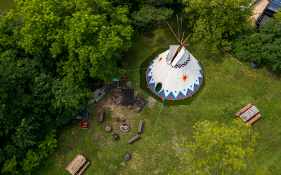 The Marymound fire pit and tipi area is shown from above with trees surrounding it.